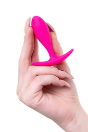 Plug anale rosa fucsia forma T tenuto in mano