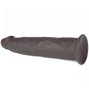 Dildo vibrante nero in silicone posizionato orizzontalmente con logo DC e base piatta stabile
