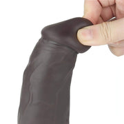 Dettaglio testa dildo vibrante nero in silicone flessibile premuta dalla mano per mostrare morbidezza